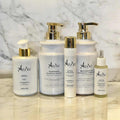 Set of Arius bath and hair products on a marble surface with a marble background