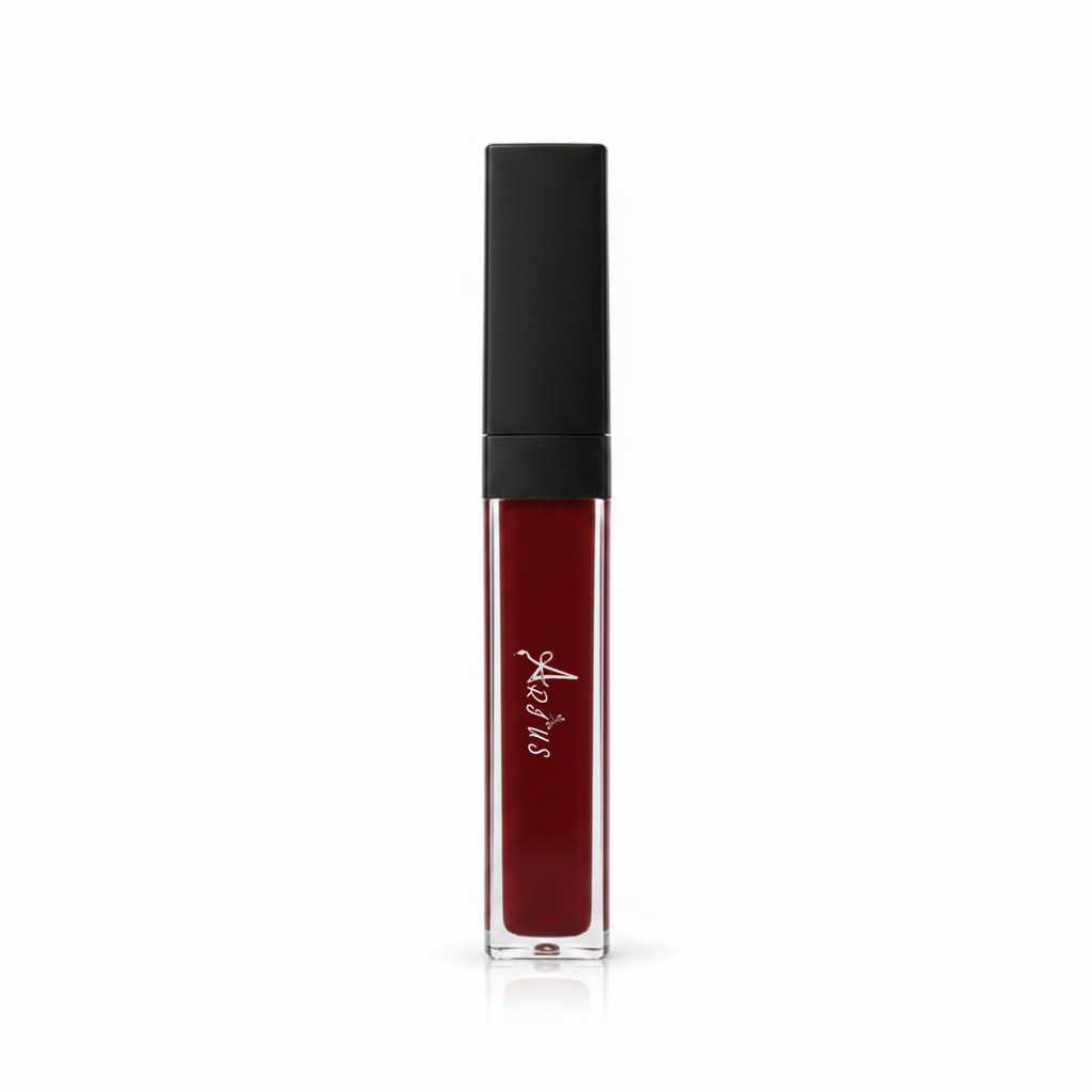 A clear rectangular tube of liquid lipstick with deep burgundy red liquid inside and a matte black cap, featuring a white script logo on the front, set against a plain white background.