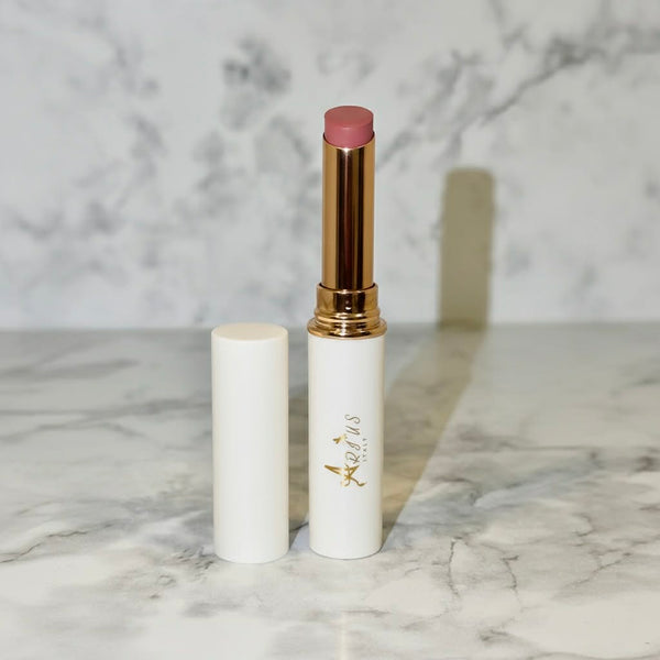Arius Italy Lip balm with gold cap and white container on marble surface
