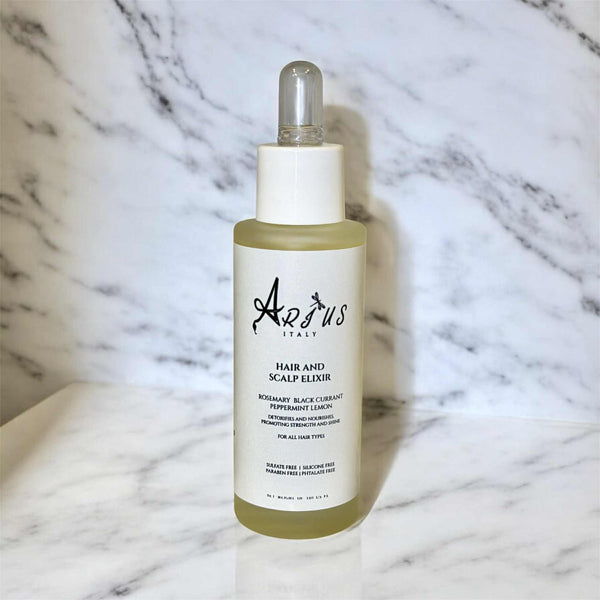 Bottle of Arius Italy hair and scalp elixir on a marble background